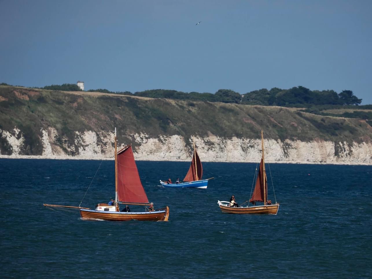 three Coble sailing boats